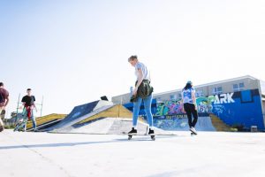 Group of teenagers skateboarding at the skate park.